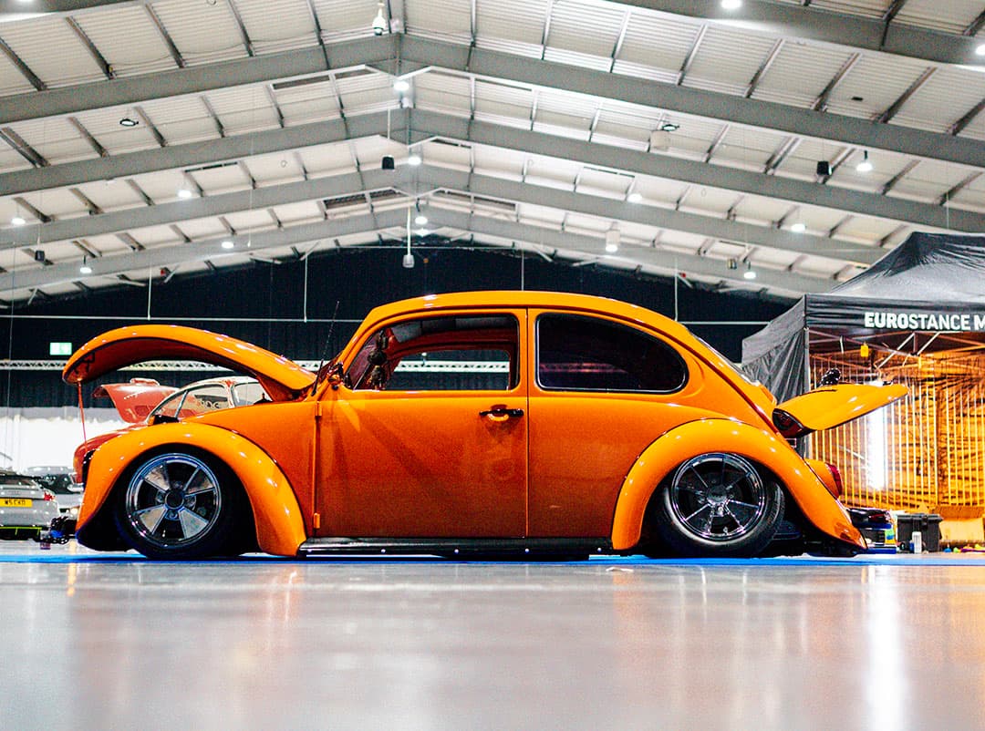 Orange 1970s VW beetle vehicle featured at Ultimate Dubs UK 2024 with Air Lift Performance